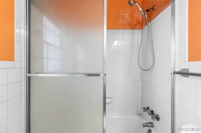 bathroom with shower / bath combination with glass door