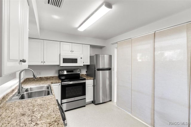 kitchen with stainless steel appliances, a sink, visible vents, white cabinets, and light countertops