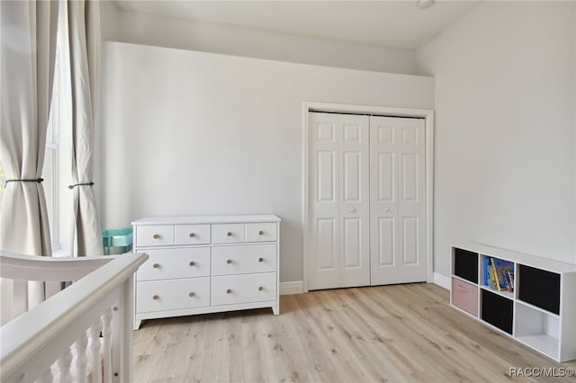 unfurnished bedroom featuring a closet and light wood-type flooring