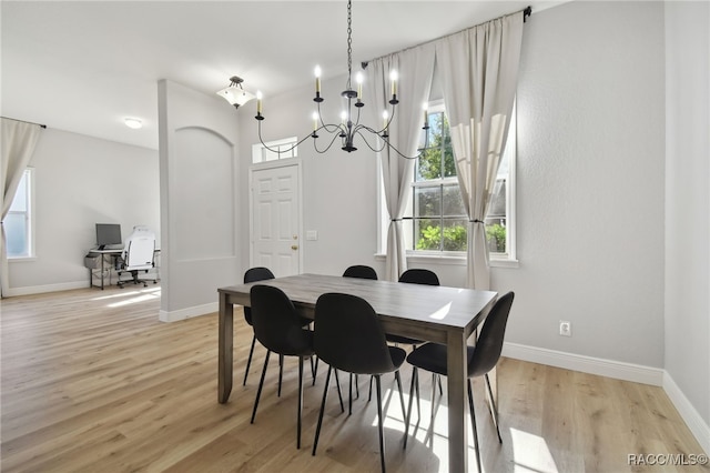 dining space featuring light hardwood / wood-style floors and a notable chandelier