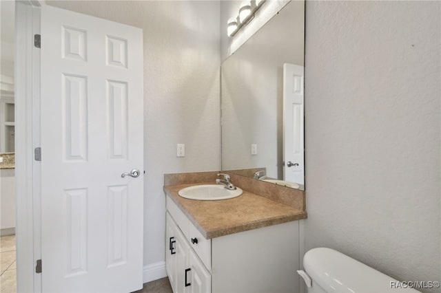 bathroom with tile patterned floors, vanity, and toilet