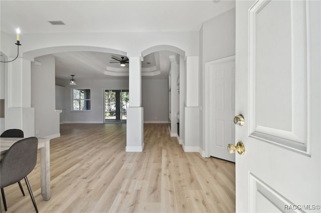 entryway featuring ceiling fan, light hardwood / wood-style floors, french doors, and a tray ceiling