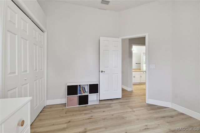 unfurnished bedroom with a closet and light hardwood / wood-style floors