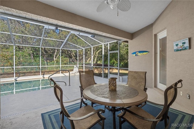 view of patio / terrace with outdoor dining area, a lanai, and a ceiling fan