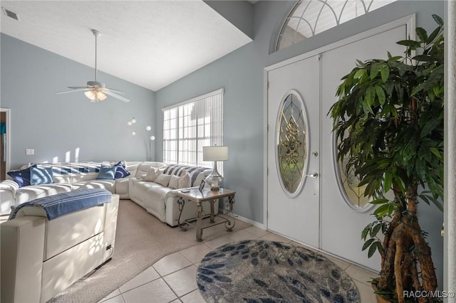 entryway featuring lofted ceiling, light tile patterned flooring, a ceiling fan, and visible vents