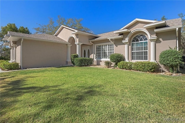 view of front facade with stucco siding and a front lawn