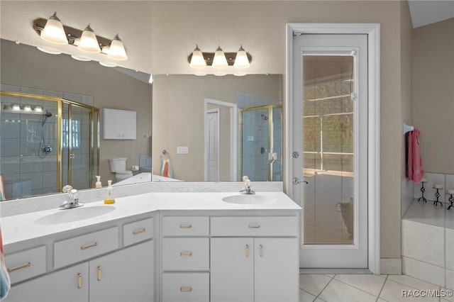 bathroom with tile patterned flooring, a stall shower, double vanity, and a sink