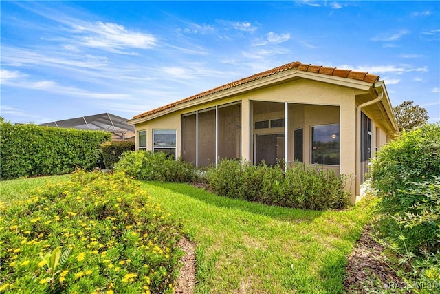 1328 W Diamond Shore Loop, Hernando, FL 34442 - back of house featuring stucco siding, a sunroom, and a yard