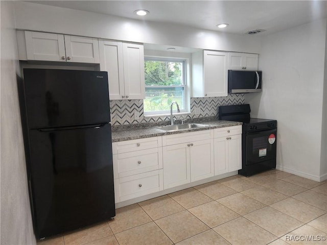 kitchen with black appliances, white cabinets, sink, light tile patterned floors, and tasteful backsplash