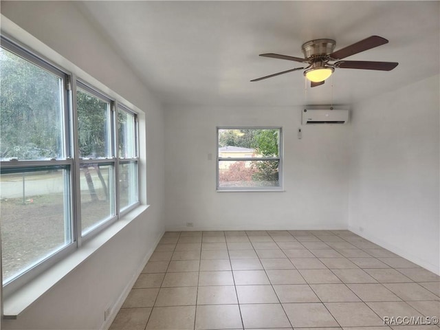 tiled spare room featuring a wall mounted AC, ceiling fan, and a healthy amount of sunlight