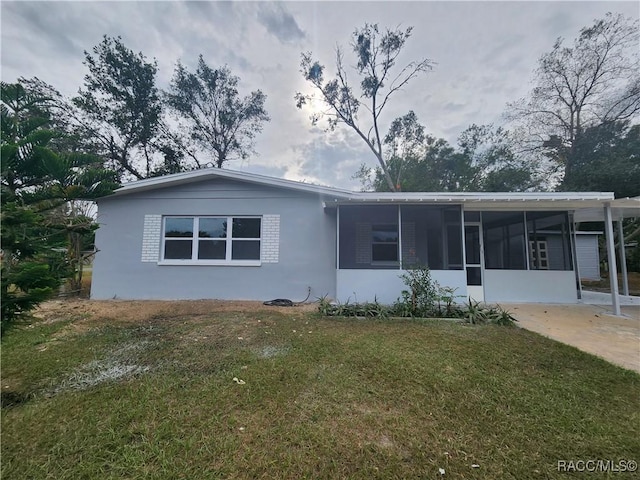 rear view of house with a lawn and a carport