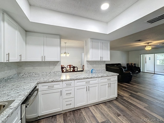 kitchen with ceiling fan with notable chandelier, stainless steel dishwasher, tasteful backsplash, dark hardwood / wood-style flooring, and white cabinetry