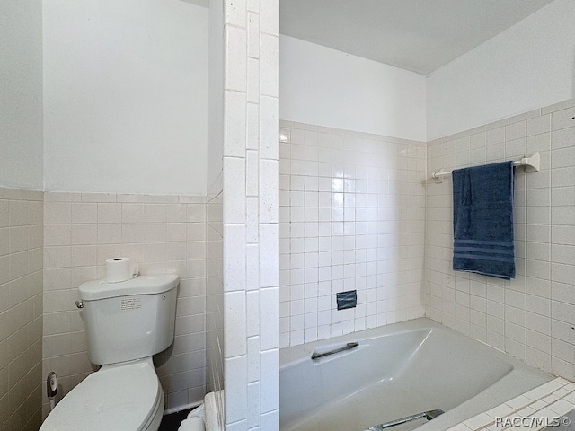 bathroom with a tub to relax in, tile walls, and toilet