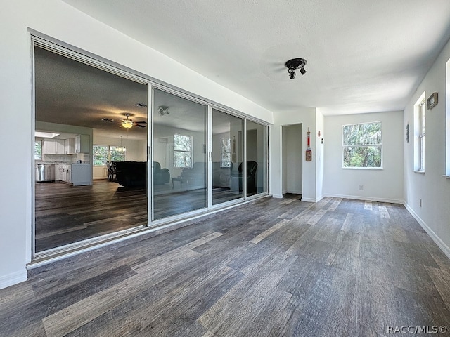 interior space with dark hardwood / wood-style flooring, plenty of natural light, and a textured ceiling