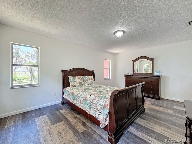 bedroom featuring dark hardwood / wood-style flooring and a textured ceiling