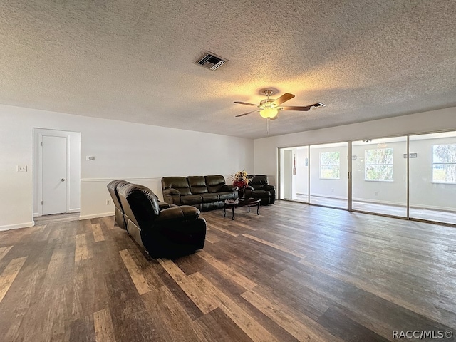 living room featuring a textured ceiling, dark hardwood / wood-style flooring, and ceiling fan