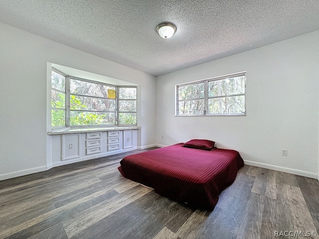 bedroom with dark wood-type flooring and a textured ceiling