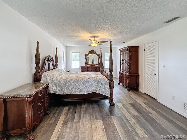 bedroom featuring ceiling fan, dark hardwood / wood-style flooring, and a textured ceiling