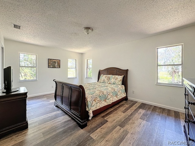 bedroom featuring a textured ceiling and dark hardwood / wood-style flooring