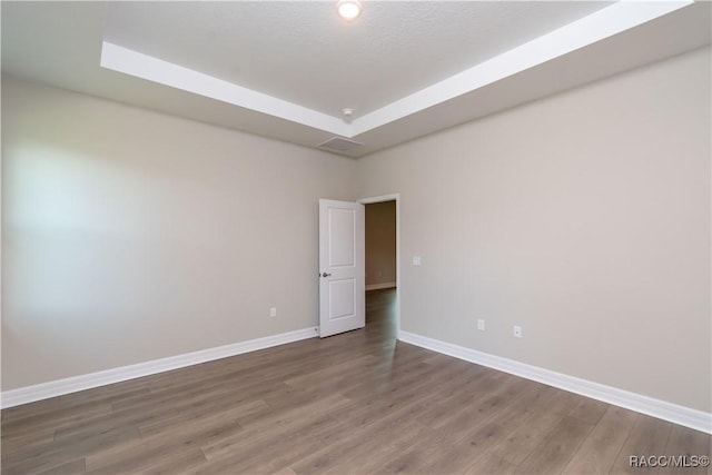 9276 N Alpinia Dr, Citrus Springs, FL 34434 - unfurnished room with baseboards, wood finished floors, and a tray ceiling