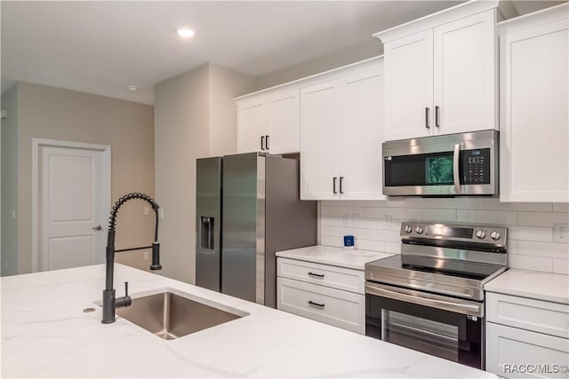 9276 N Alpinia Dr, Citrus Springs, FL 34434 - kitchen featuring stainless steel appliances, a sink, white cabinets, decorative backsplash, and recessed lighting