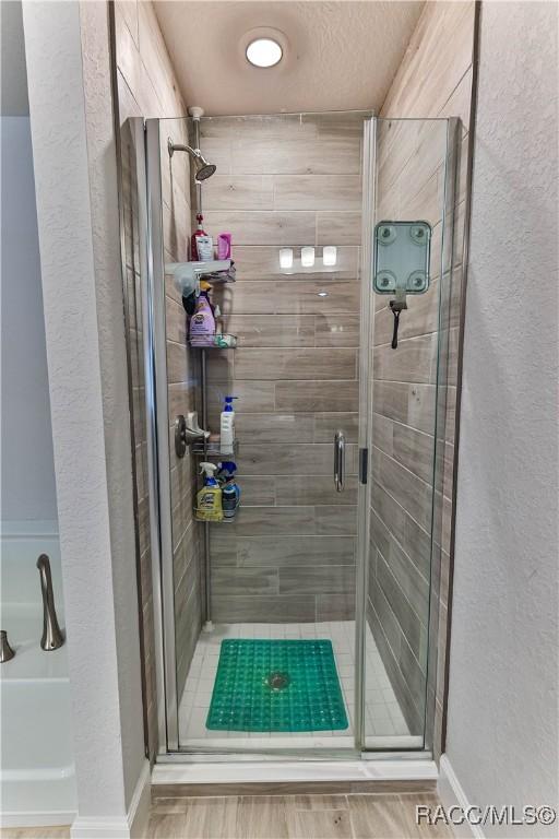 bathroom featuring a shower with door and hardwood / wood-style floors