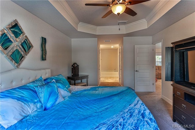 carpeted bedroom with ceiling fan, ensuite bath, ornamental molding, and a tray ceiling