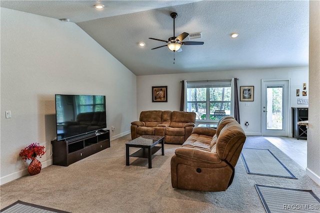 living room with vaulted ceiling, carpet, ceiling fan, and a textured ceiling