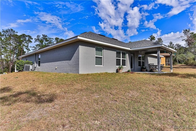 back of house featuring central AC, a patio area, and a lawn