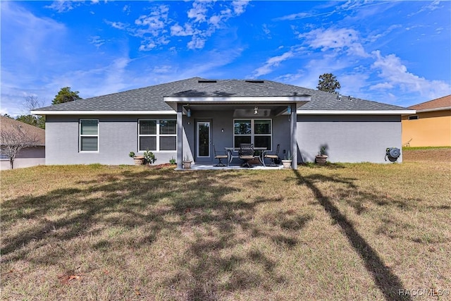 back of property with a yard and a patio