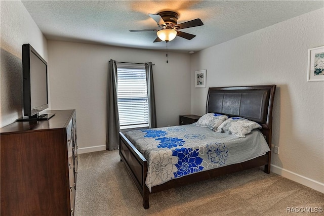 carpeted bedroom with ceiling fan and a textured ceiling