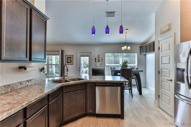 kitchen with sink, light hardwood / wood-style flooring, stainless steel appliances, dark brown cabinetry, and decorative light fixtures