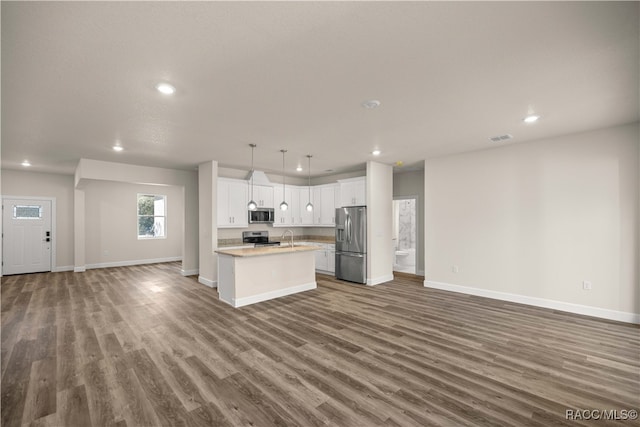 kitchen with white cabinetry, stainless steel appliances, dark hardwood / wood-style flooring, decorative light fixtures, and a kitchen island