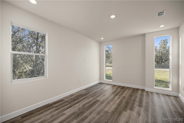 unfurnished room with dark wood-type flooring