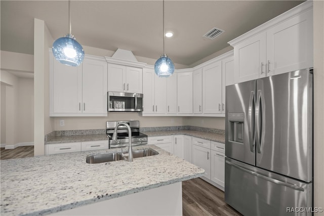 kitchen featuring white cabinetry, dark hardwood / wood-style flooring, decorative light fixtures, and appliances with stainless steel finishes