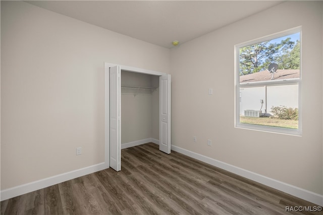 unfurnished bedroom with dark hardwood / wood-style flooring and a closet