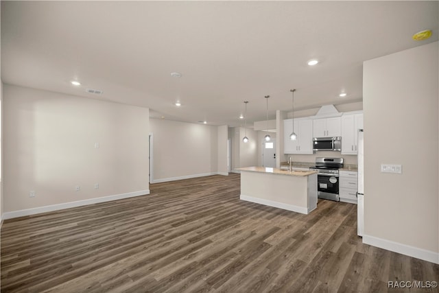 kitchen featuring appliances with stainless steel finishes, dark hardwood / wood-style flooring, a center island with sink, white cabinets, and hanging light fixtures