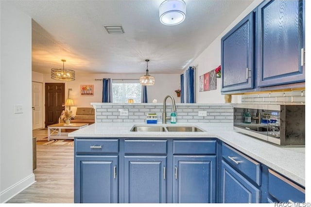 kitchen with sink, pendant lighting, and blue cabinets