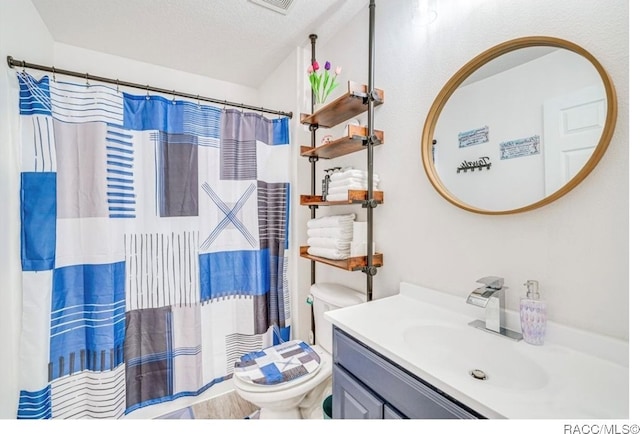 bathroom with a shower with shower curtain, vanity, toilet, and a textured ceiling