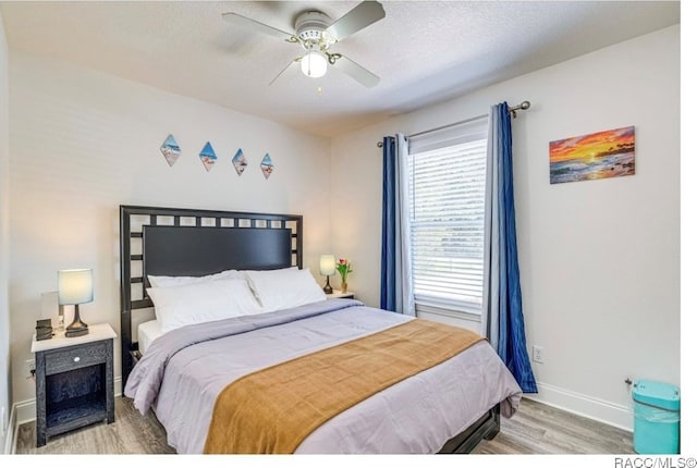 bedroom featuring hardwood / wood-style flooring, ceiling fan, and a textured ceiling