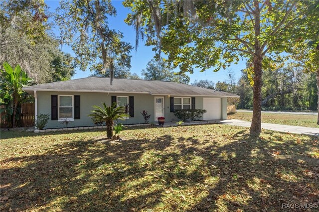 ranch-style house featuring a garage and a front lawn