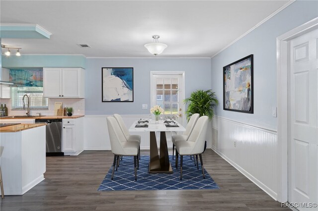 dining room featuring crown molding, dark hardwood / wood-style flooring, and sink