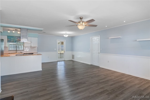 unfurnished living room with dark hardwood / wood-style floors, ceiling fan, and ornamental molding