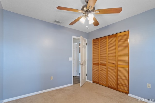 unfurnished bedroom with a closet, ceiling fan, and light colored carpet