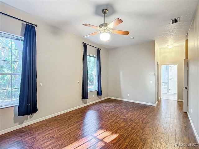 spare room with ceiling fan and dark wood-type flooring