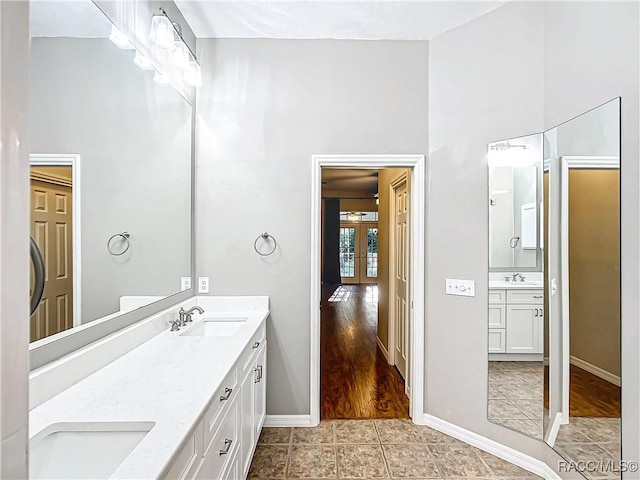 bathroom with vanity, wood-type flooring, a towering ceiling, and french doors