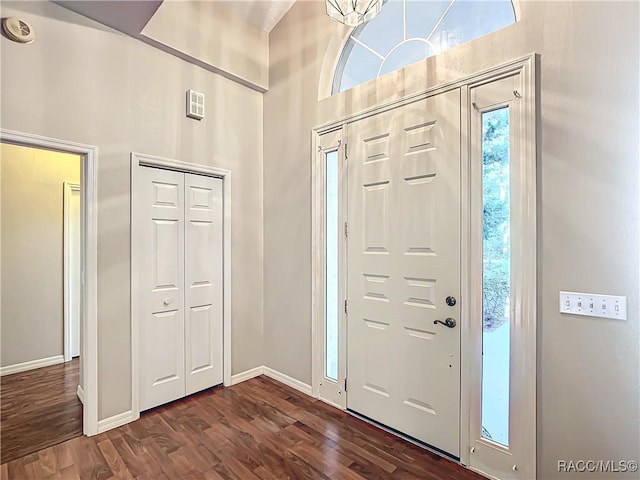 entrance foyer with an inviting chandelier and dark wood-type flooring