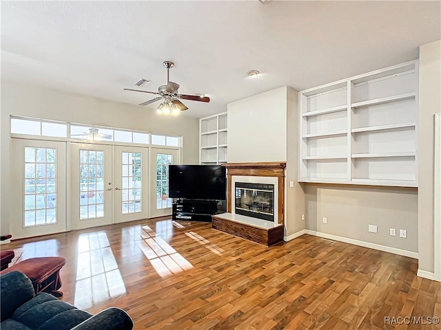 living room with ceiling fan, hardwood / wood-style floors, and french doors