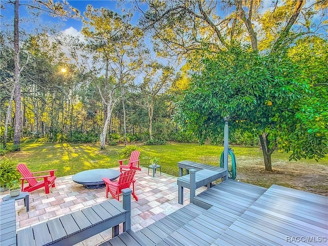 deck featuring a lawn, a fire pit, and a patio