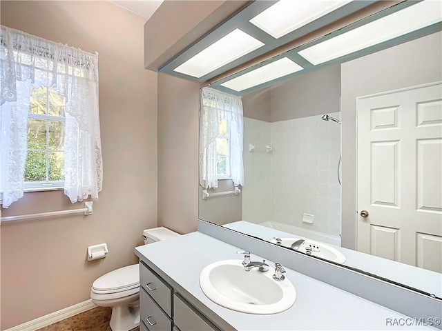 full bathroom with tile patterned floors, vanity, tiled shower / bath combo, and toilet